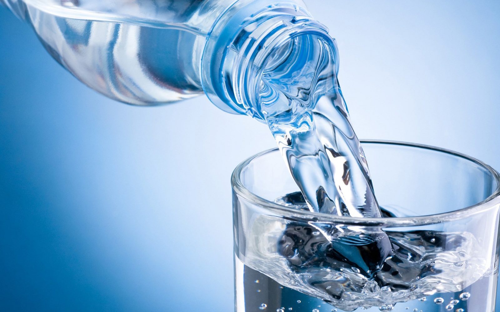 Минеральная вода наливается в прозрачный стакан