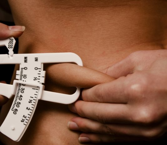 Девушка измеряет процент жира в организме