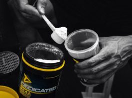 Атлет кладет из баночки bcaa черпачком аминокислоты в шейкер