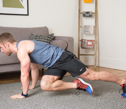 Спортивный мужчина тренируется в домашних условиях