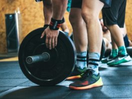 Атлет собирает штангу в тренажерном зале