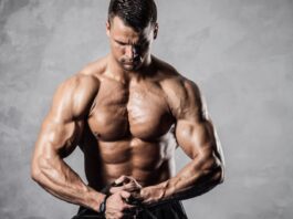 Культурист (бодибилдер) натурал позирует накаченный торс